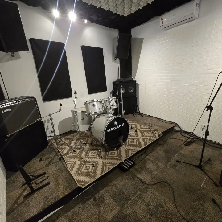 Sala 1 com bateria Nagano, amplificador Laney, painéis acústicos e microfone