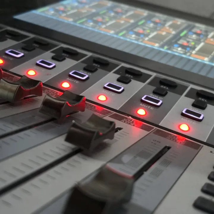 Faders iluminados da mesa de som digital na sala técnica